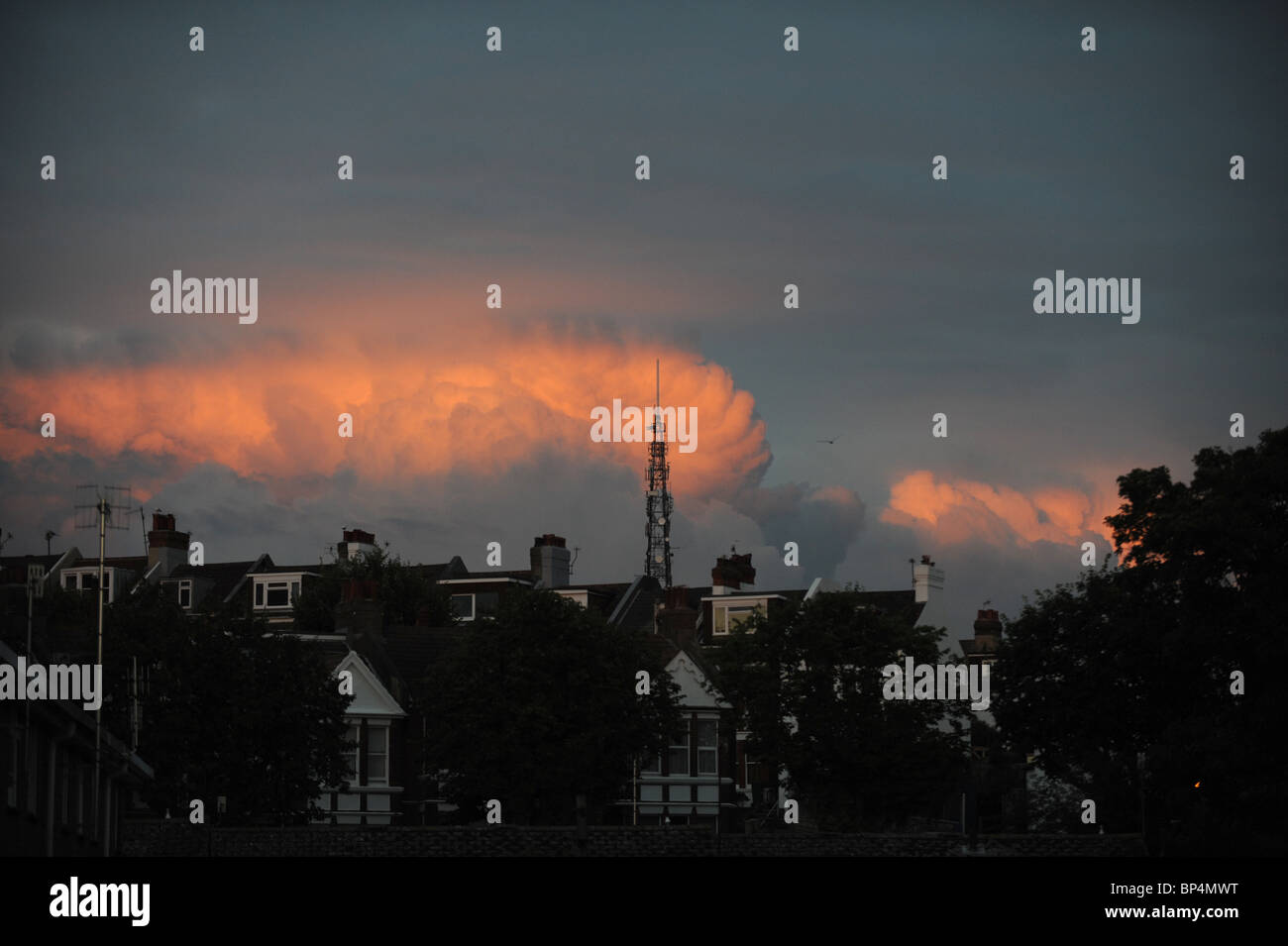 Sonnenuntergang spiegelt sich auf Wolken über dem Sender Pylon in Brighton UK Stockfoto