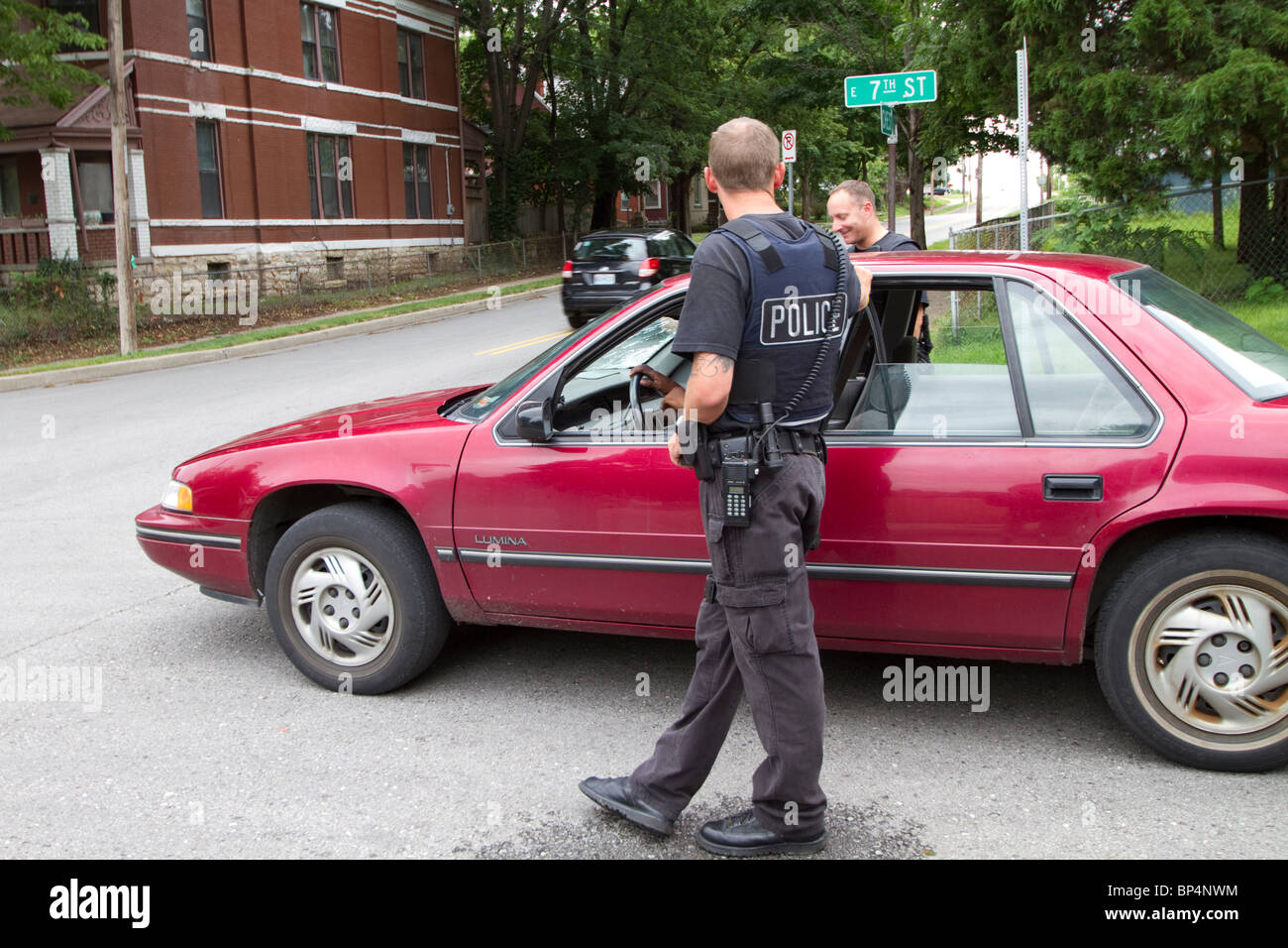 Polizisten aus taktischen Team im Gespräch mit einer Person gefunden, schlafen in einem Fahrzeug in einem Knotenpunkt. Kansas City, MO, PD. Stockfoto