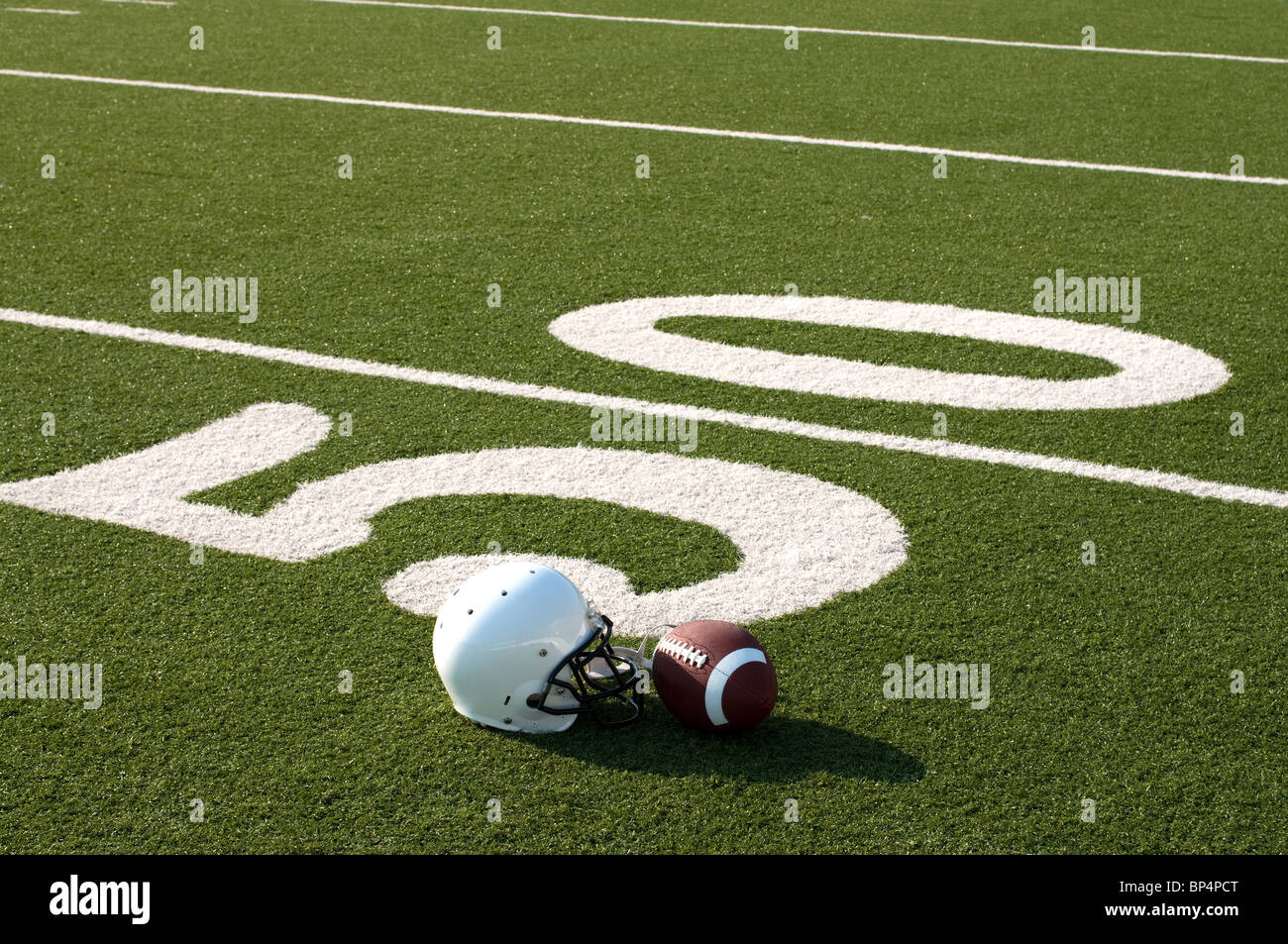 American Football und Helm auf Feld. Stockfoto