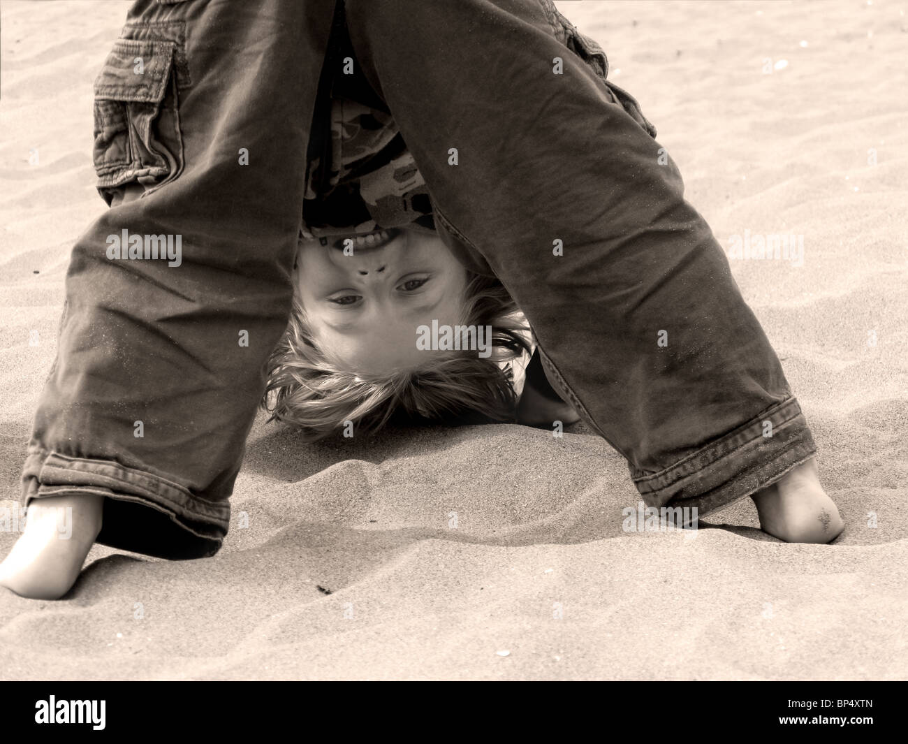 Junge auf der Suche durch die Beine Stockfoto