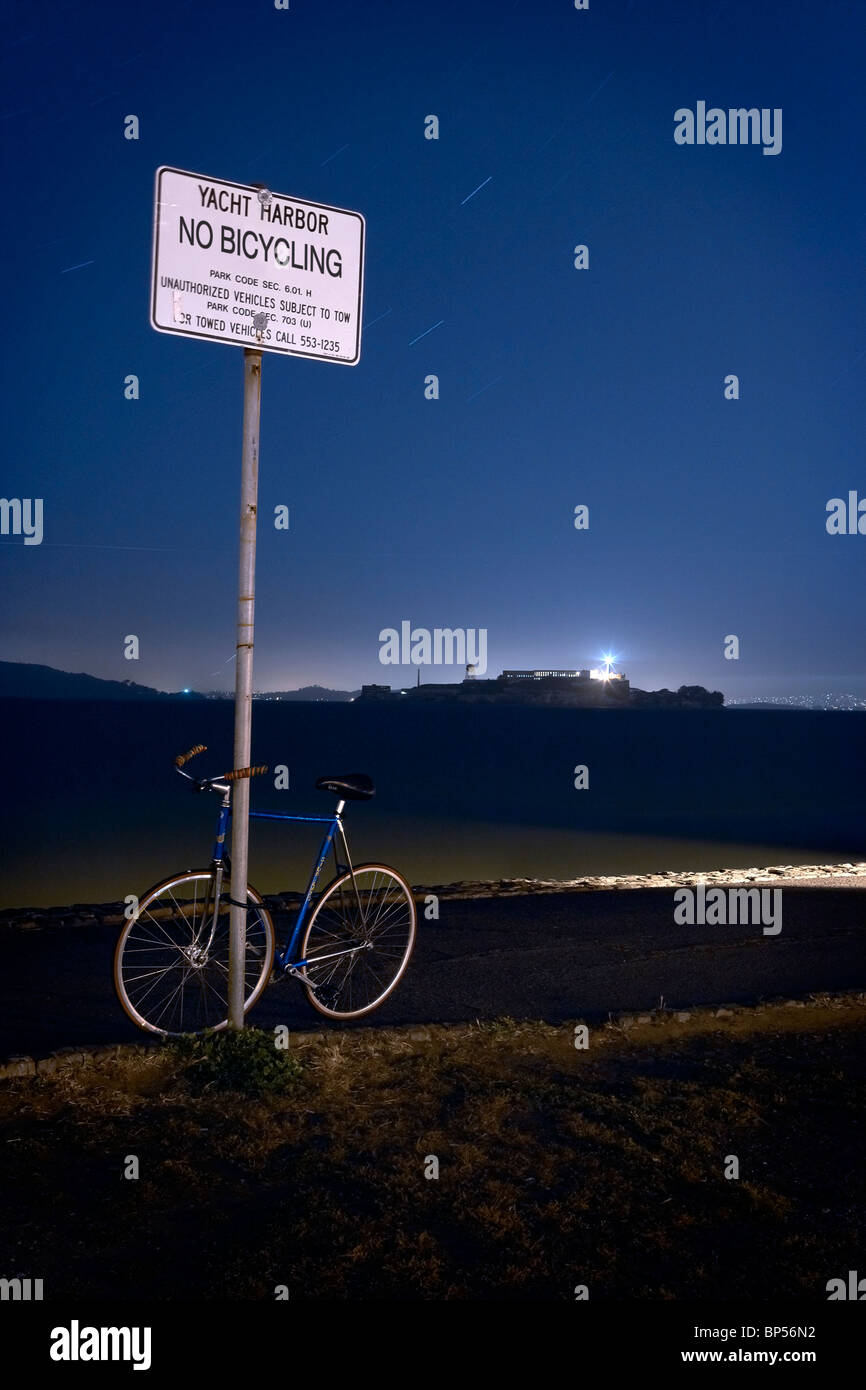 Ein Push-Bike eingesperrt, kein Radfahren Zeichen in der Nacht mit Alcatraz im Hintergrund. Stockfoto