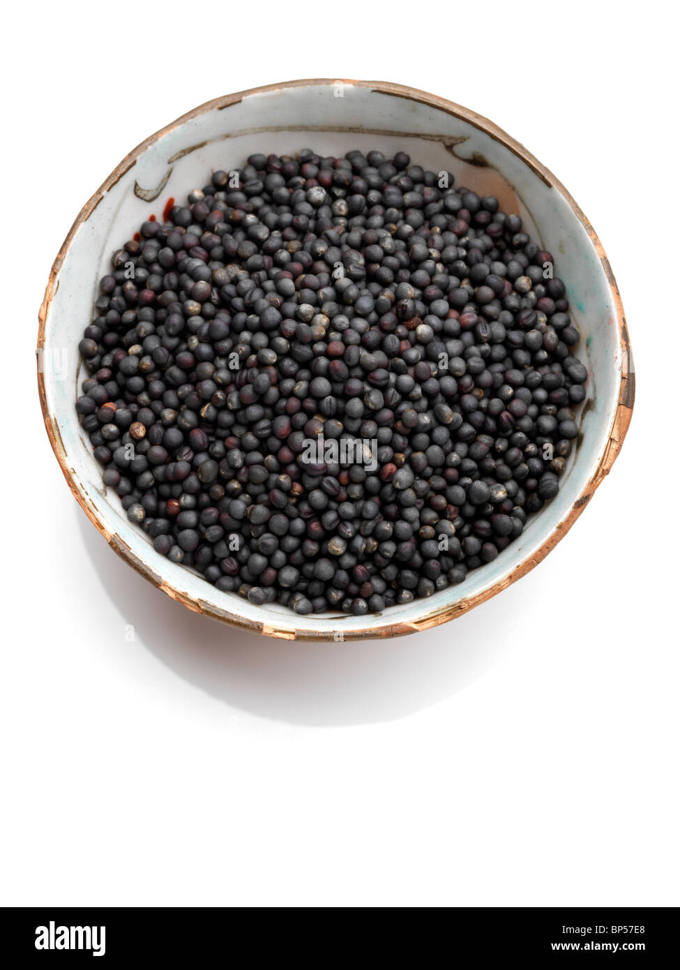 Eine Schale mit schwarzen Senfsamen auf weißem Hintergrund Stockfoto