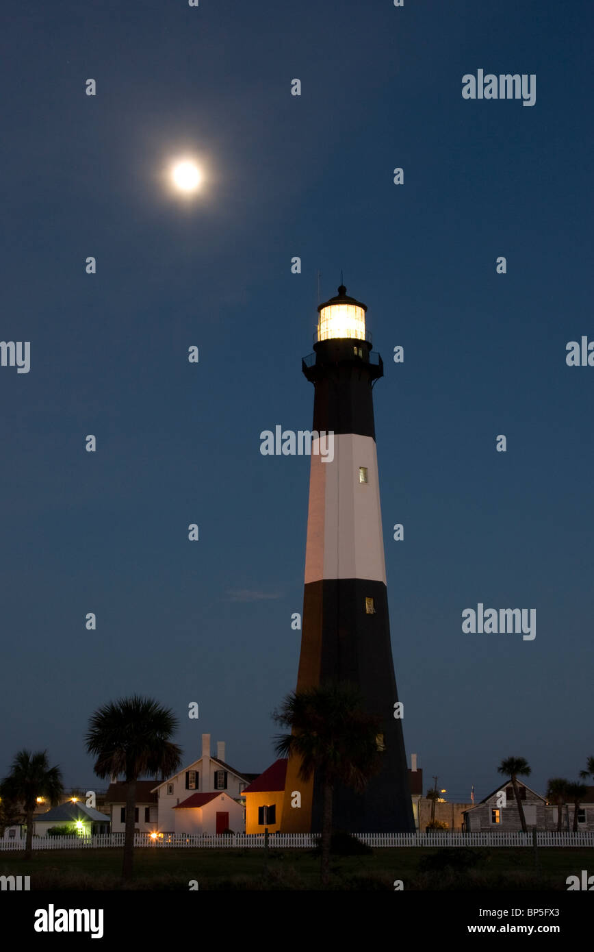 Ein Leuchtturm auf Tybee Island, Georgia bei Vollmond in der Dämmerung Stockfoto