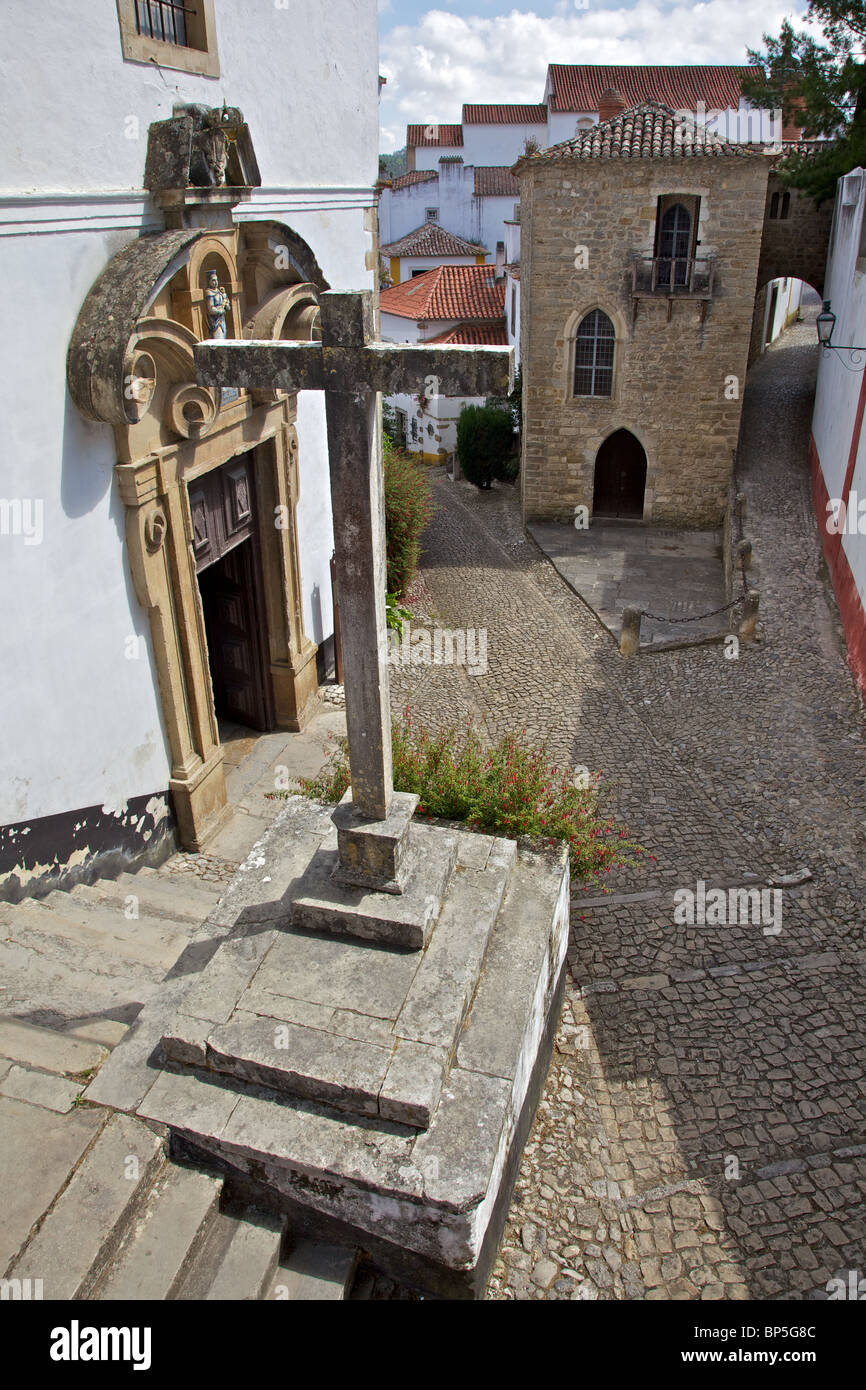 Massive Steinkreuz außerhalb einer Kirche in dem mittelalterlichen Dorf Obidos Stockfoto