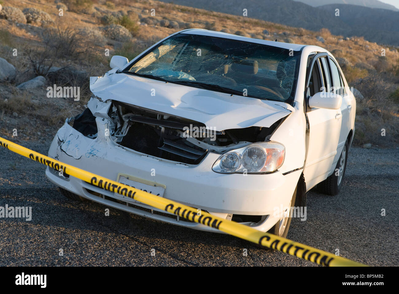 Zertrümmerten Auto abgesperrt hinter Polizei Klebeband Stockfoto