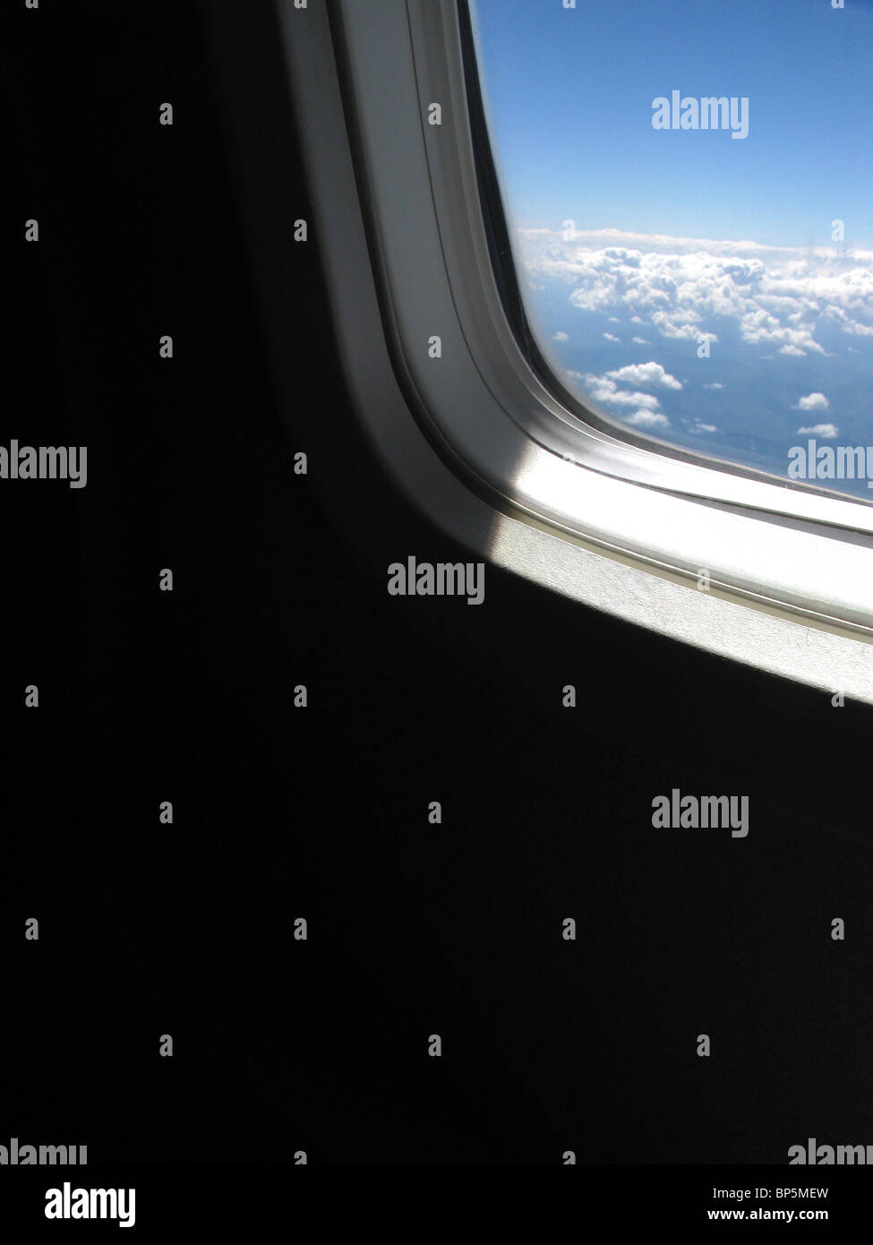 Ein Passagier Blick auf ein Flugzeug Fenster außerhalb Tageslicht mit blauen Himmel und Wolken Stockfoto