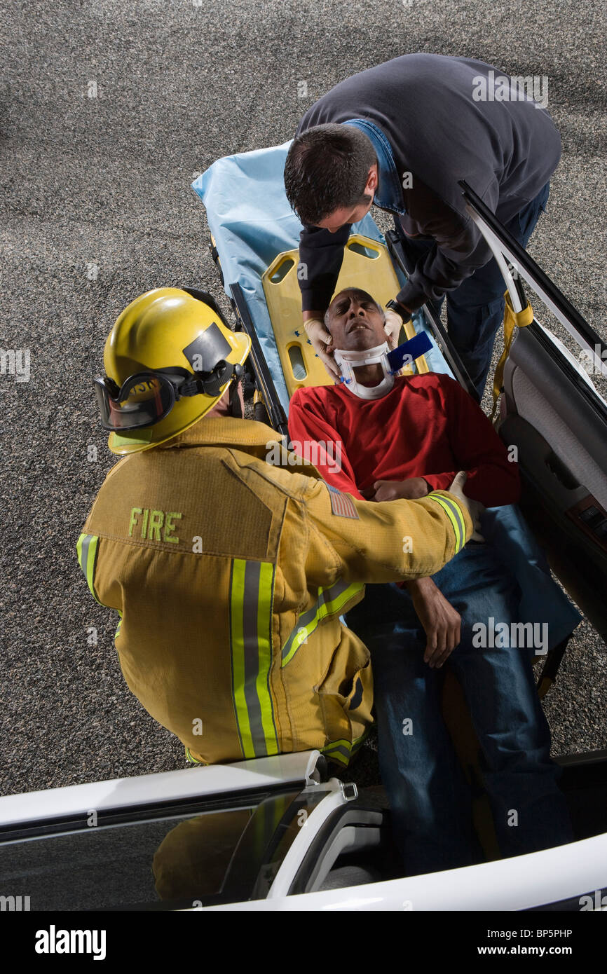 Feuerwehrmann und Rettungssanitäter Rettung Auto Unfallopfer Stockfoto