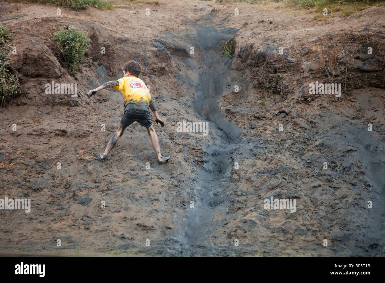 Kinder spielen in einem schlammigen Bach bei Blakeney, North Norfolk, Großbritannien. Stockfoto