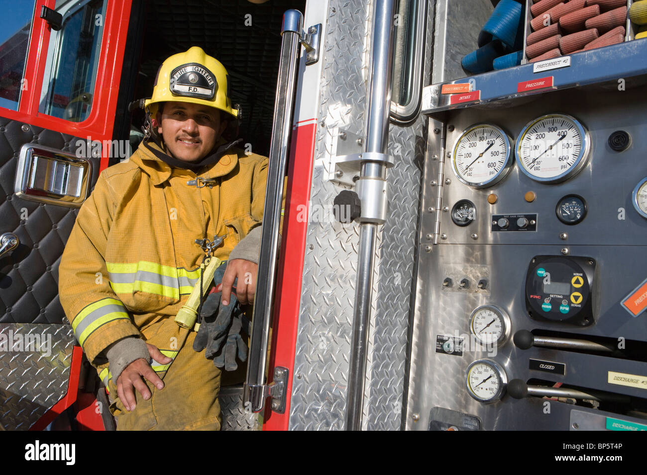 Feuerwehrmann sitzt auf Feuerwehrauto Stockfoto
