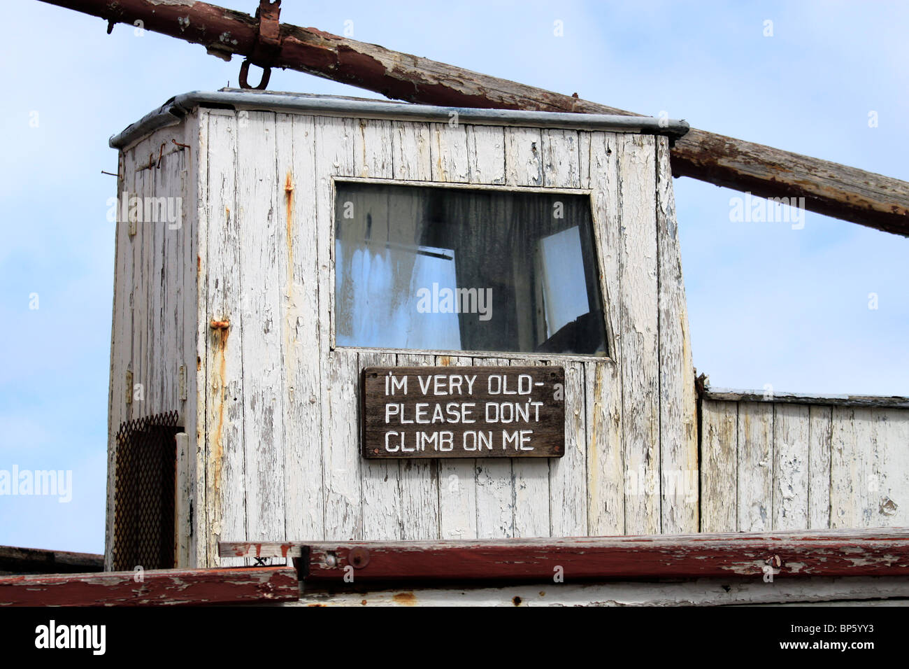 Alte Wetter geschlagen Boot mit Schild "bin ich sehr alt - bitte nicht auf mich" in Hout Bay Hafen in der Nähe von Kapstadt, Südafrika. Stockfoto