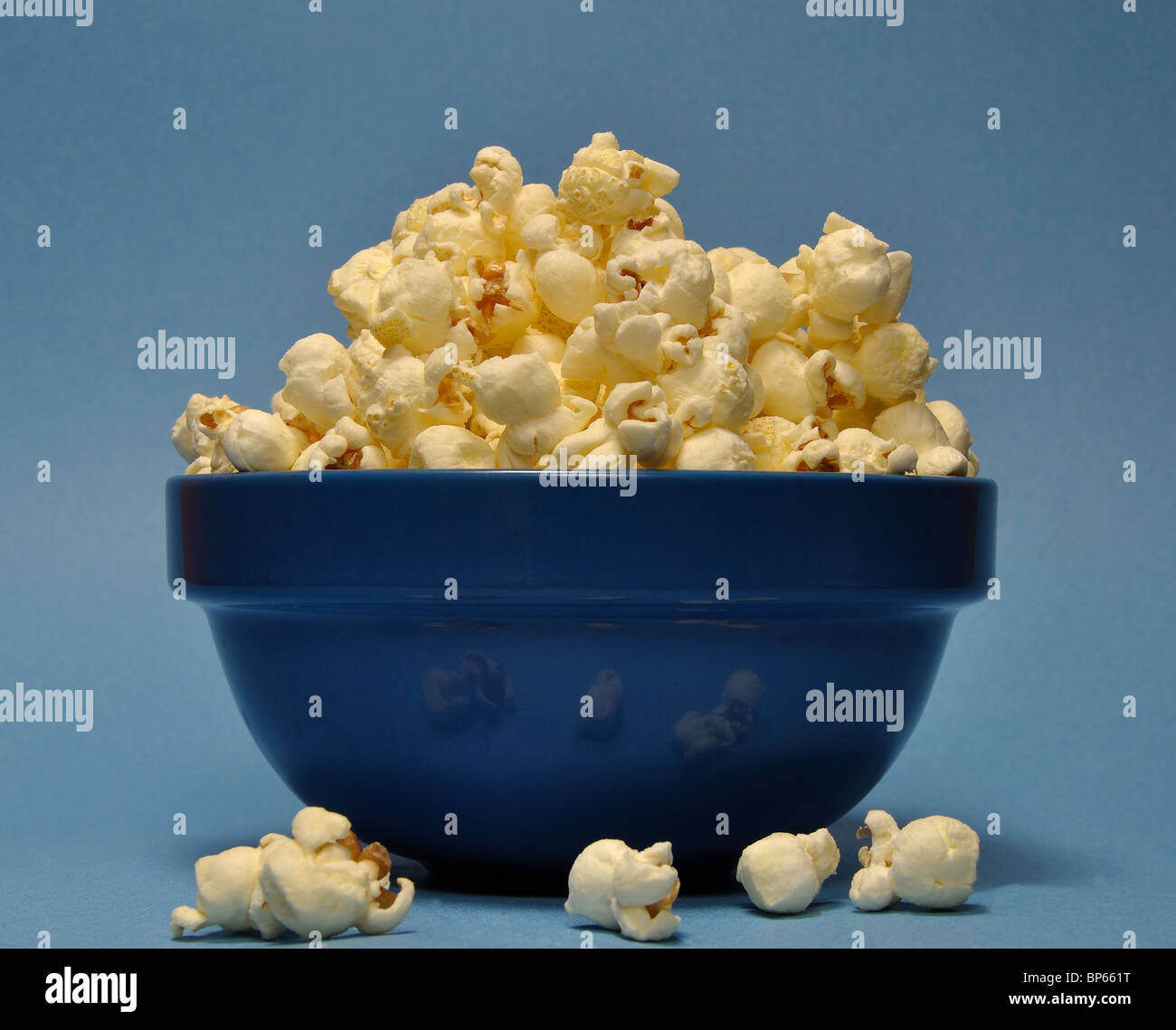 Popcorn in blaue Schale auf blauem Hintergrund Stockfoto