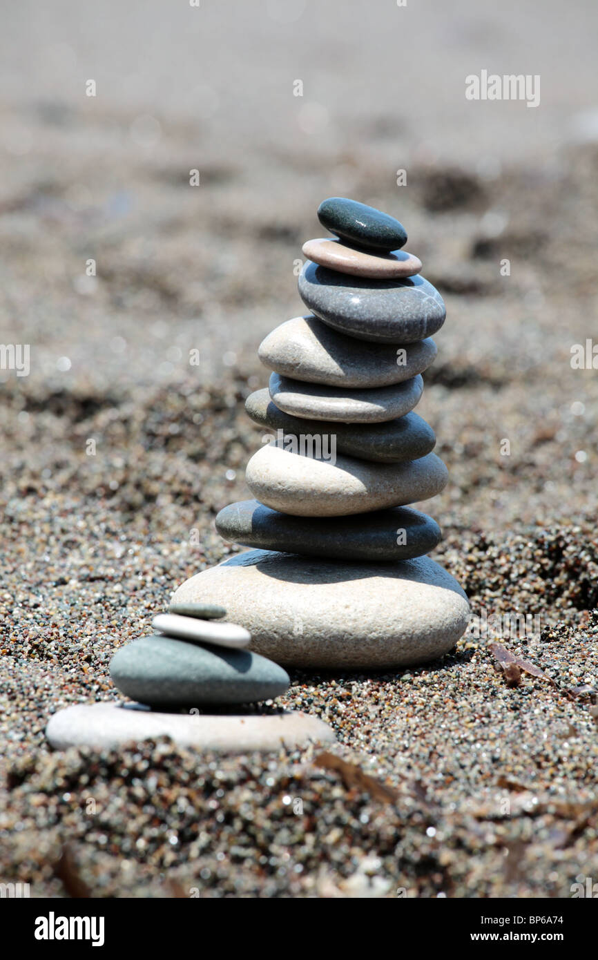 Ausgewogene Steinen am Strandsand. Vertikale Zusammensetzung. Flachen DOF. Stockfoto