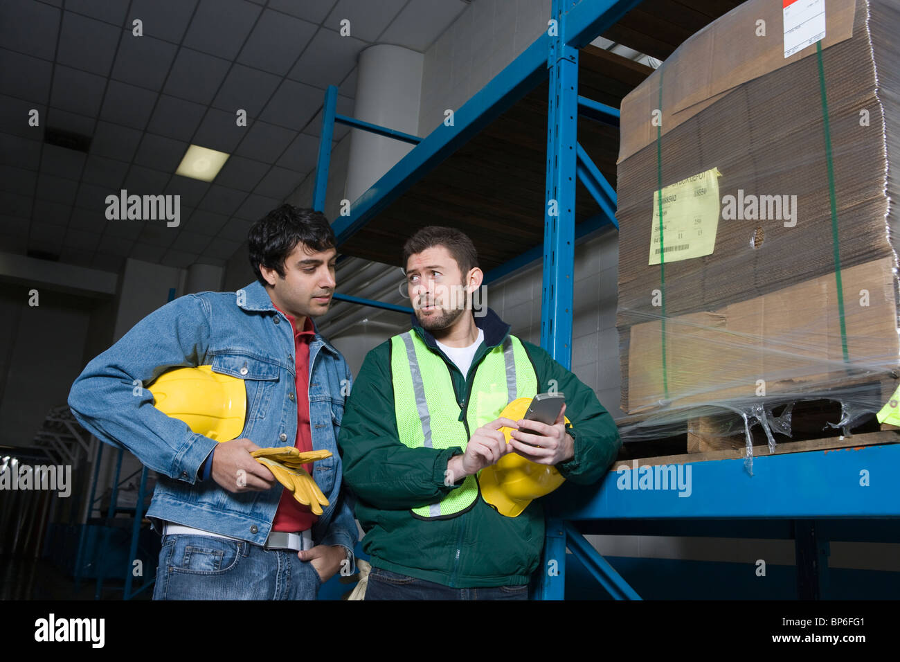 Männer mit Taschenrechner in Fabrik Stockfoto