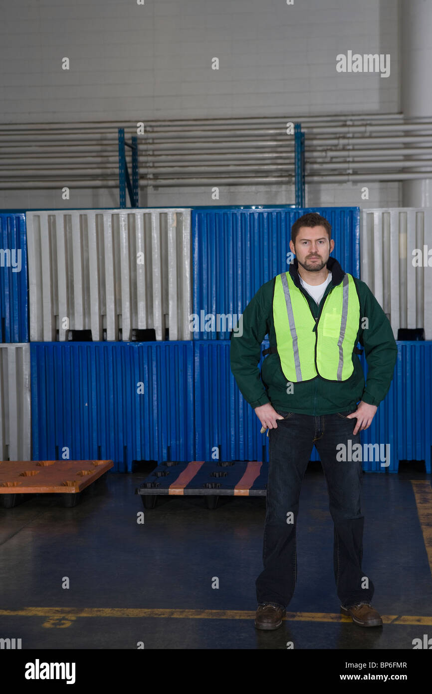 Mann in Fabrik, Hände auf den Hüften Stockfoto