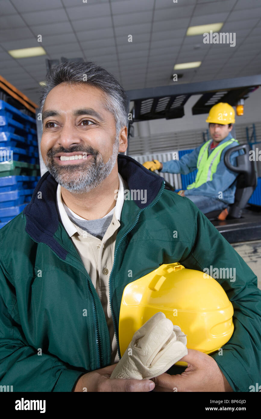 Fröhlicher Mann, der im Werk Stockfoto