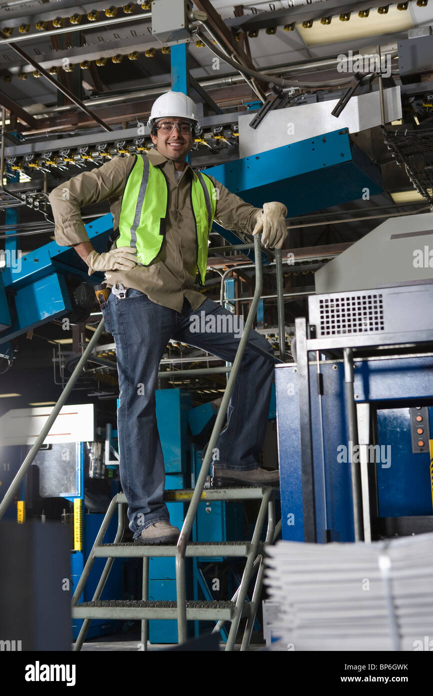 Mann arbeitet in der Fabrik, auf Treppen Stockfoto