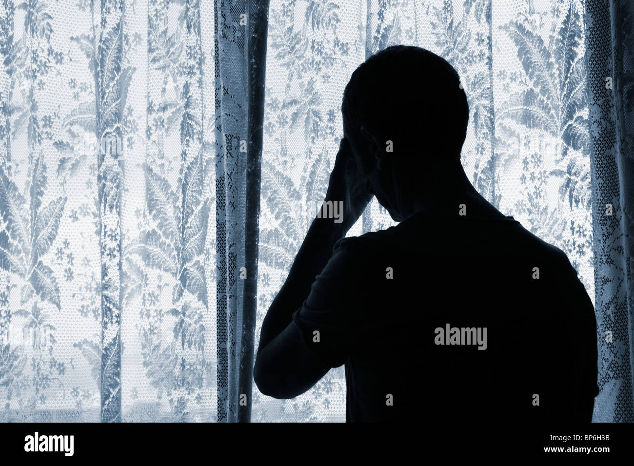 Mann schaut aus dem Fenster.Konzept Bild; Depression, Einsamkeit, Angst, PTSD, Männlicher Selbstmord... Stockfoto