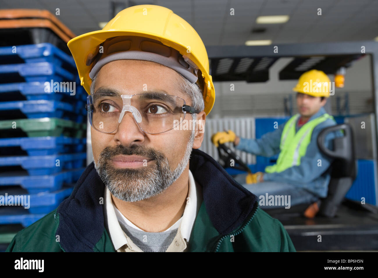 Ernster Mann stehend in Fabrik, Hart Hut Stockfoto