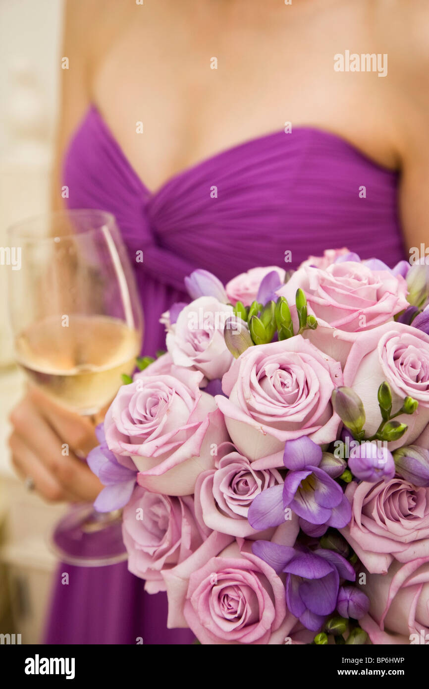 Mittelteil eine Brautjungfer mit einem Blumenstrauß und einem Glas Wein Stockfoto