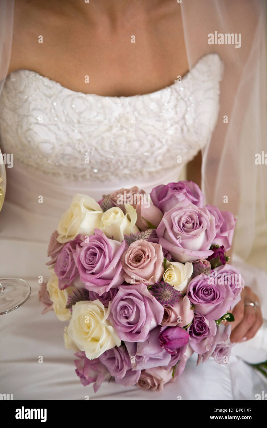 Mittelteil einer Braut hält einen Blumenstrauß Stockfoto