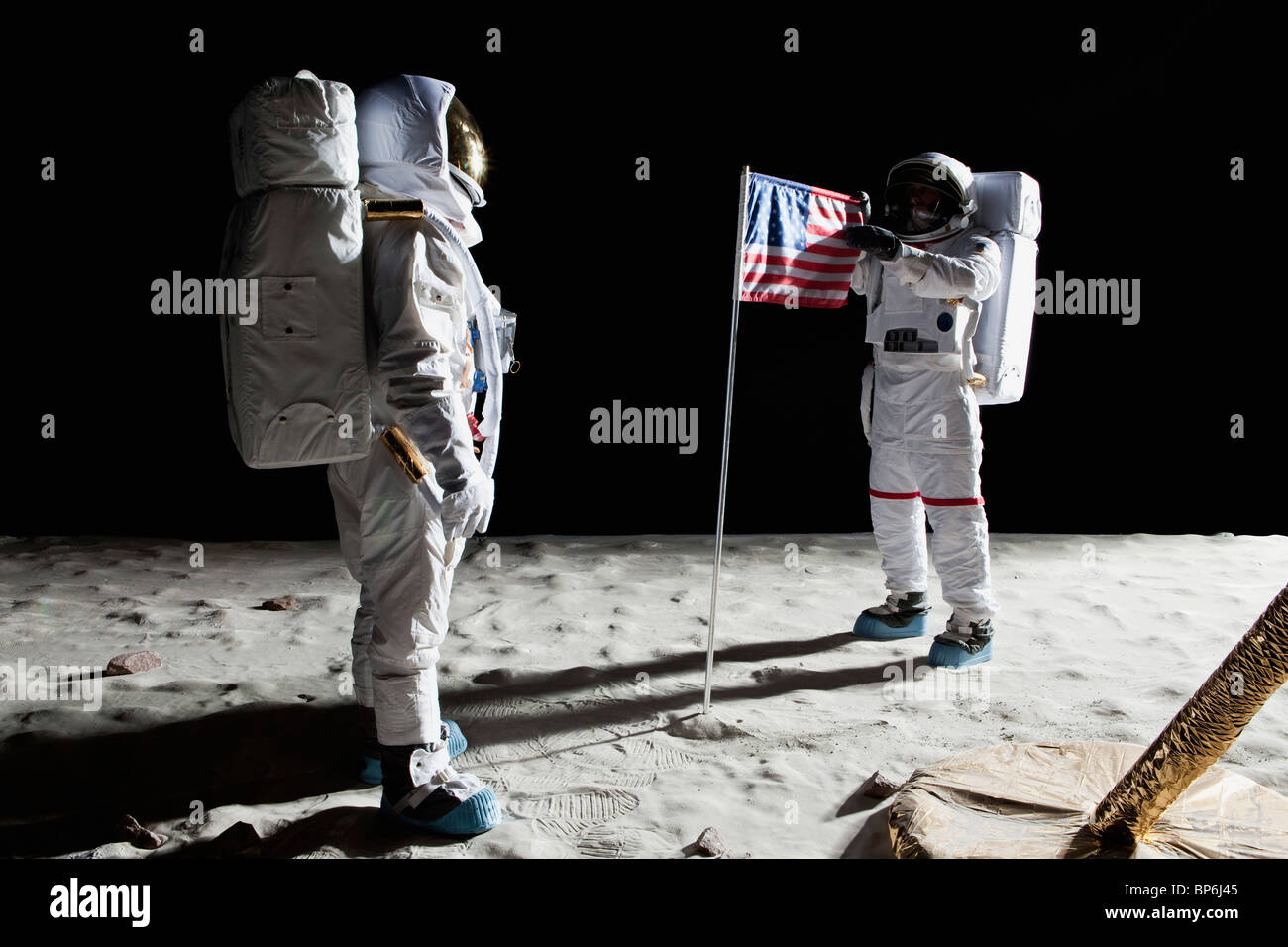 Zwei Astronauten auf dem Mond, eine amerikanische Flagge zwischen Ihnen Stockfoto