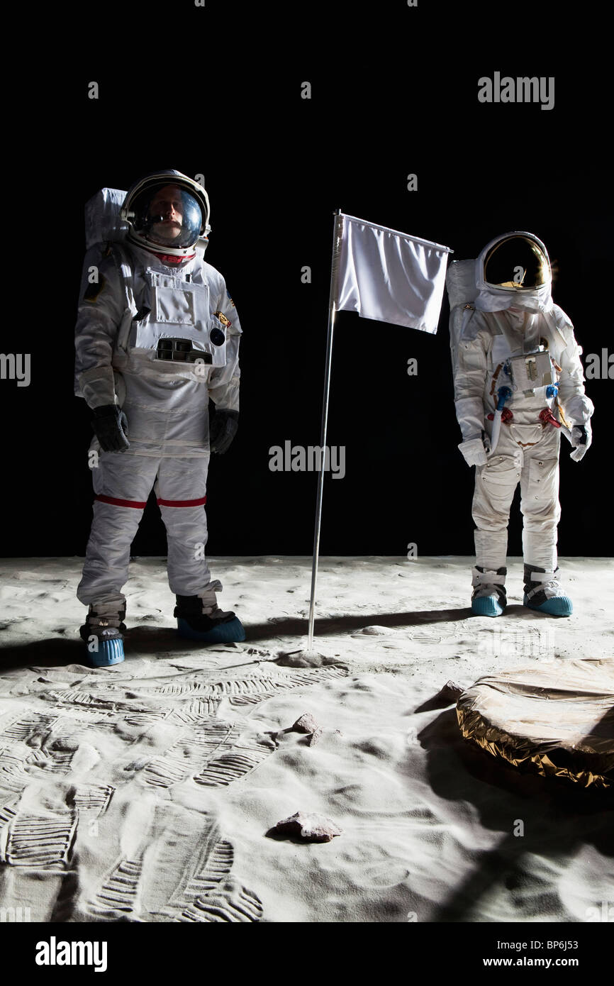 Zwei Astronauten auf dem Mond, eine leere weiße Fahne dazwischen Stockfoto