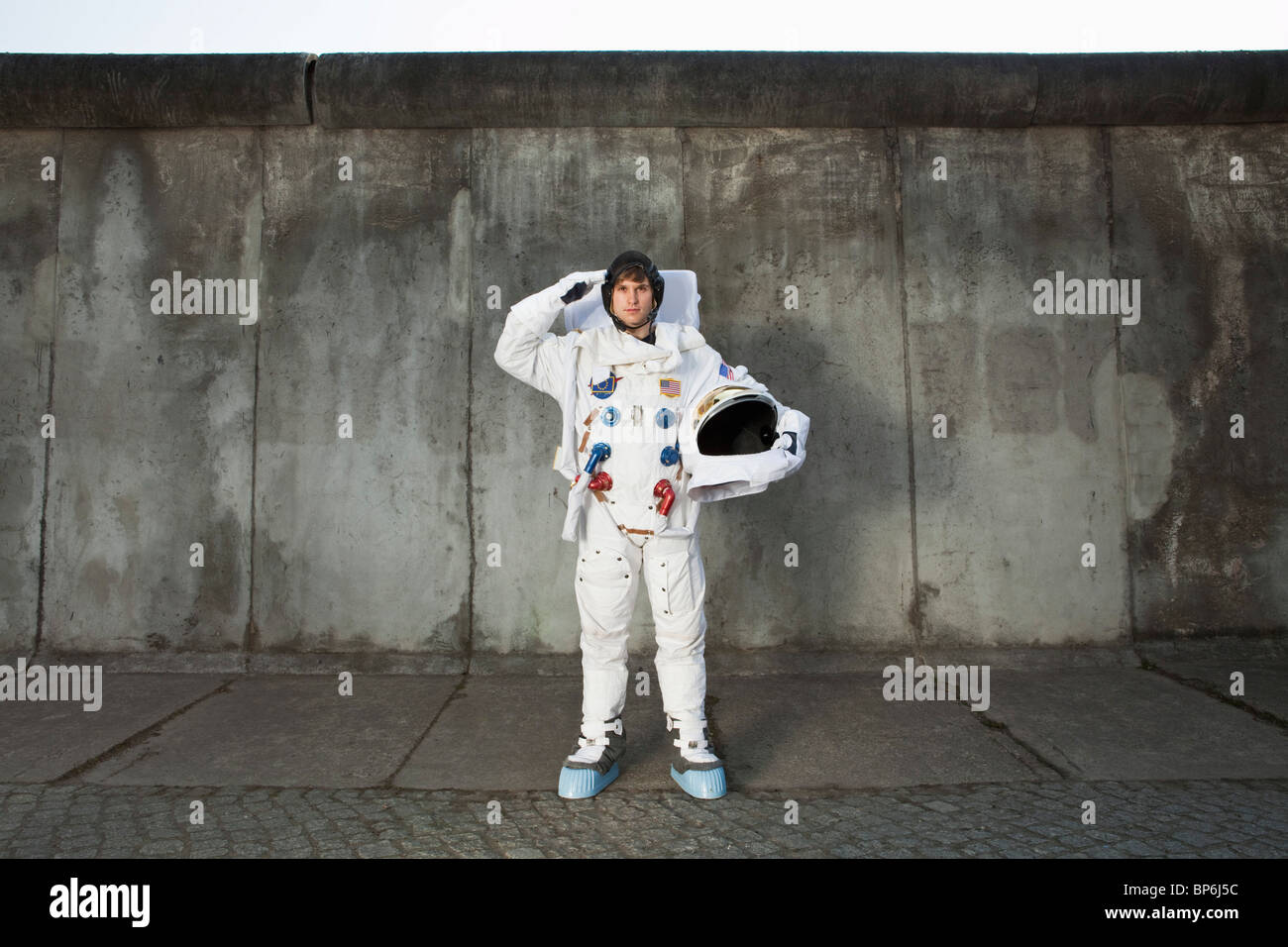 Eine begrüssende Astronaut, stehend auf einem Bürgersteig in einer Stadt Stockfoto