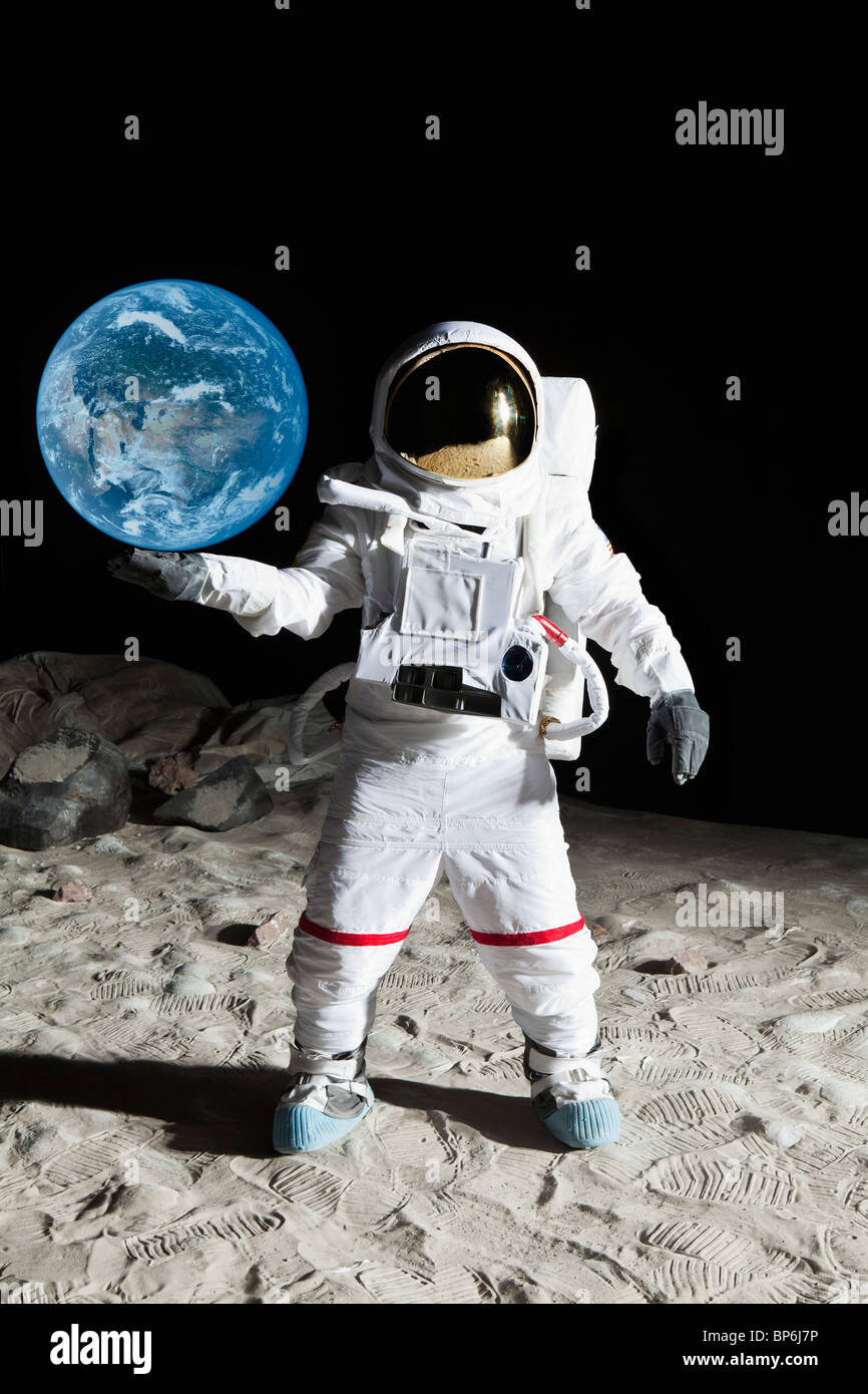 Ein Astronaut auf der Mondoberfläche, die vorgeben, halten Sie die Erde Stockfoto
