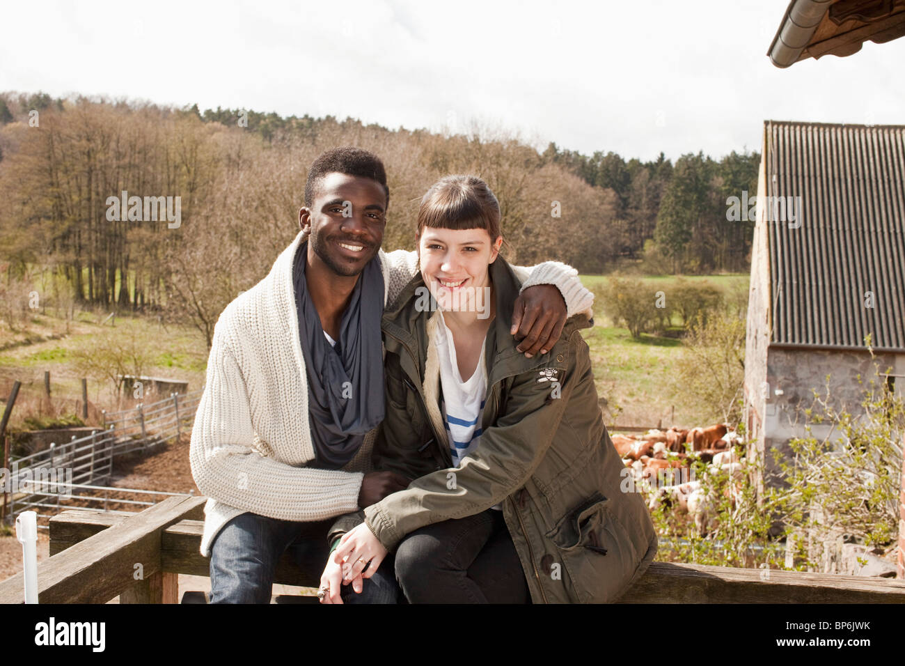 Ein junges Paar sitzt auf einem Balkongeländer Stockfoto