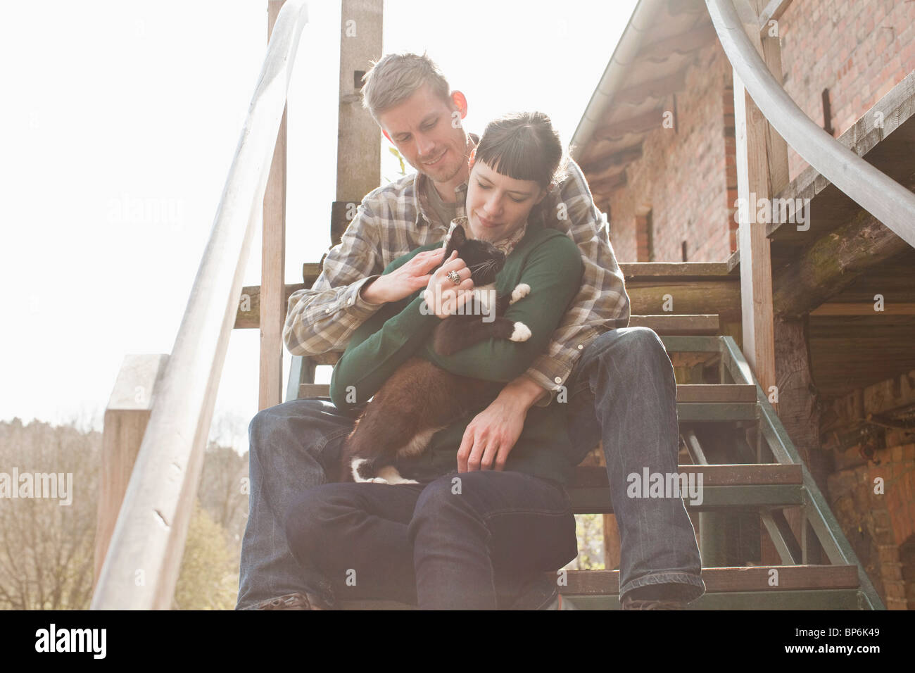 Ein paar Holding und eine Katze streicheln Stockfoto