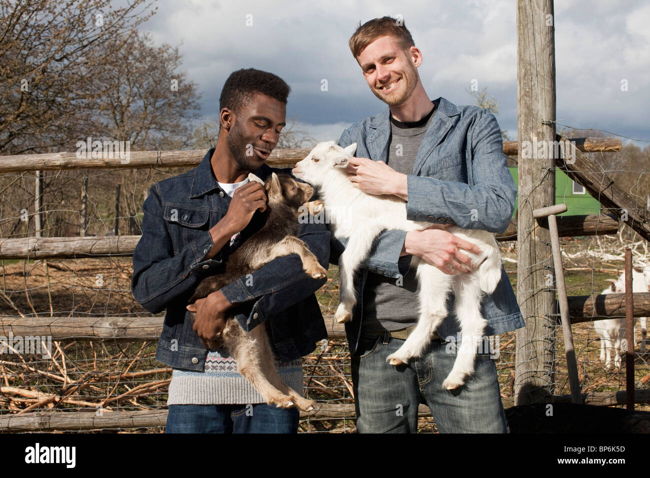 Zwei männliche Freunde Kid Ziegen halten Stockfoto