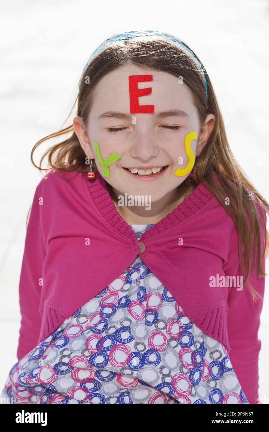 Ein Mädchen mit Filz Buchstaben Rechtschreibung ja im Gesicht Stockfoto