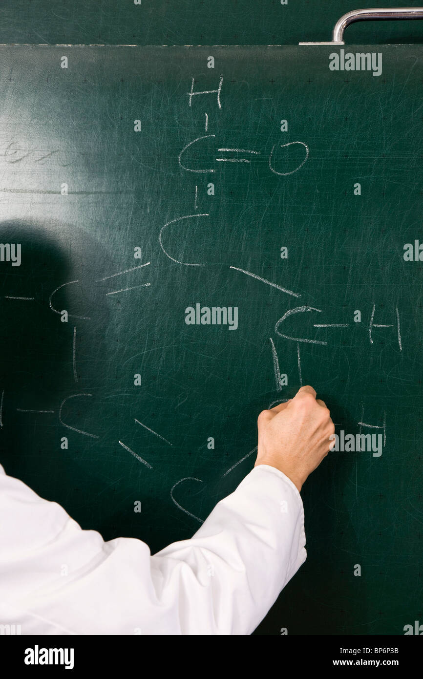 Schreiben einer Formel auf einer Kreidetafel, Fokus auf Seite Chemielehrer Stockfoto