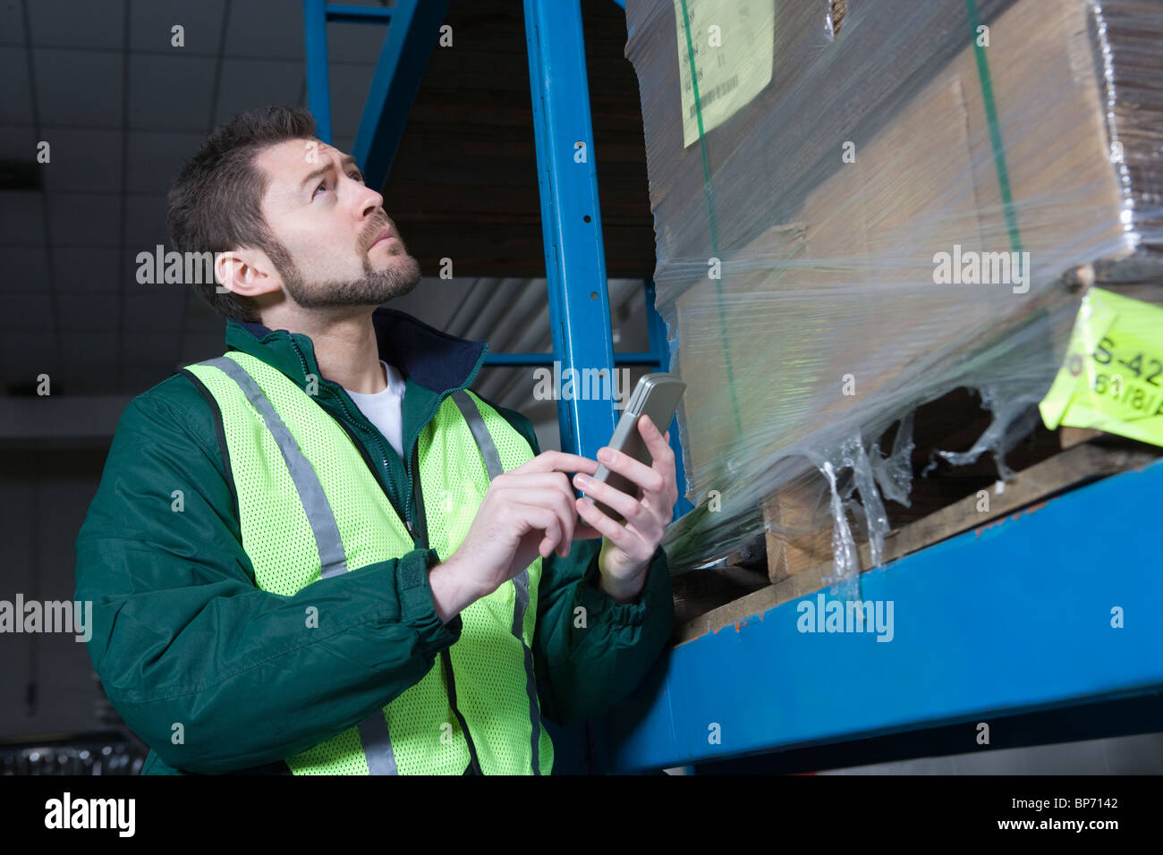 Mann mit Taschenrechner in Fabrik Stockfoto