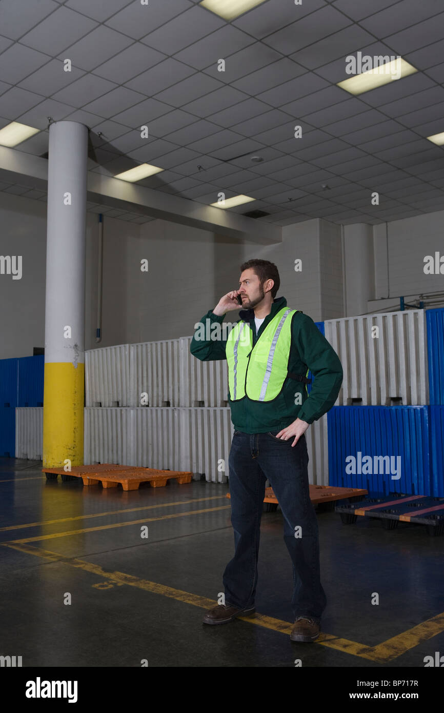 Mann stehend in Fabrik, Telefon Stockfoto