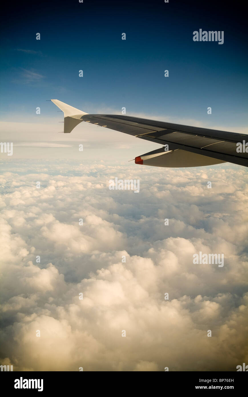 Ein Passagiere Blick auf ein Flugzeug Flügel hoch über den Wolken. Stockfoto