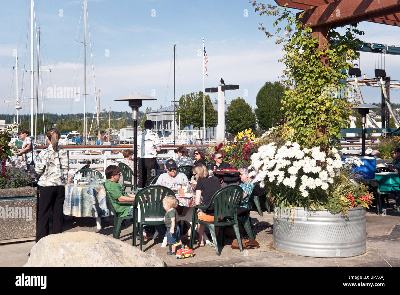 Familiengruppen genießen Essen unter freiem Himmel im Anthonys Beach Café Waterfront Restaurant an schönen Tag in Edmonds, Washington Stockfoto
