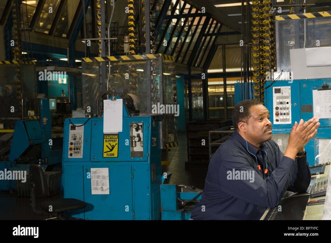 Mann arbeitet in Zeitung Fabrik Stockfoto