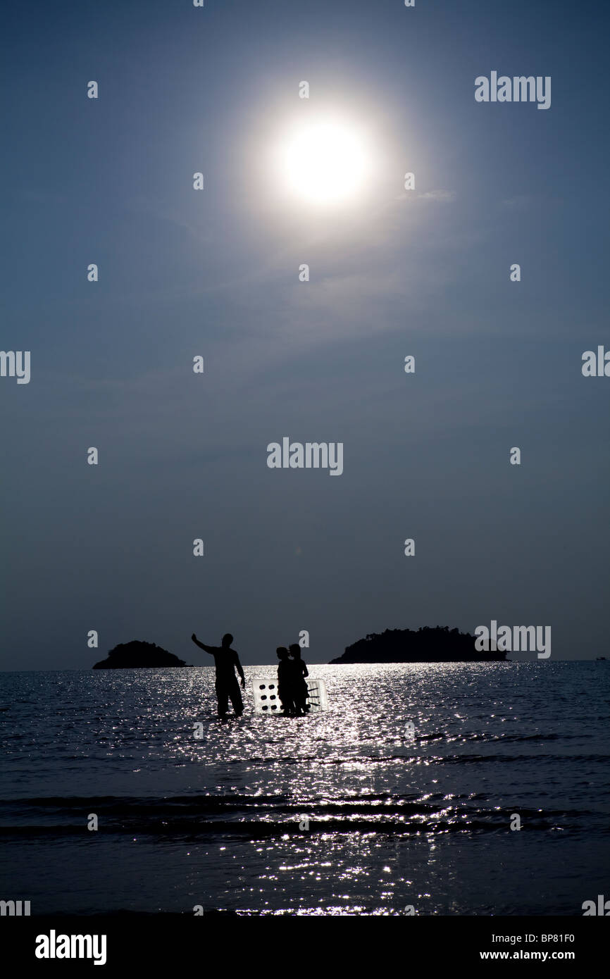 Familie Stand in das Meer und die Sonne mit einem Lilo, Koh Chang, Thailand. Stockfoto