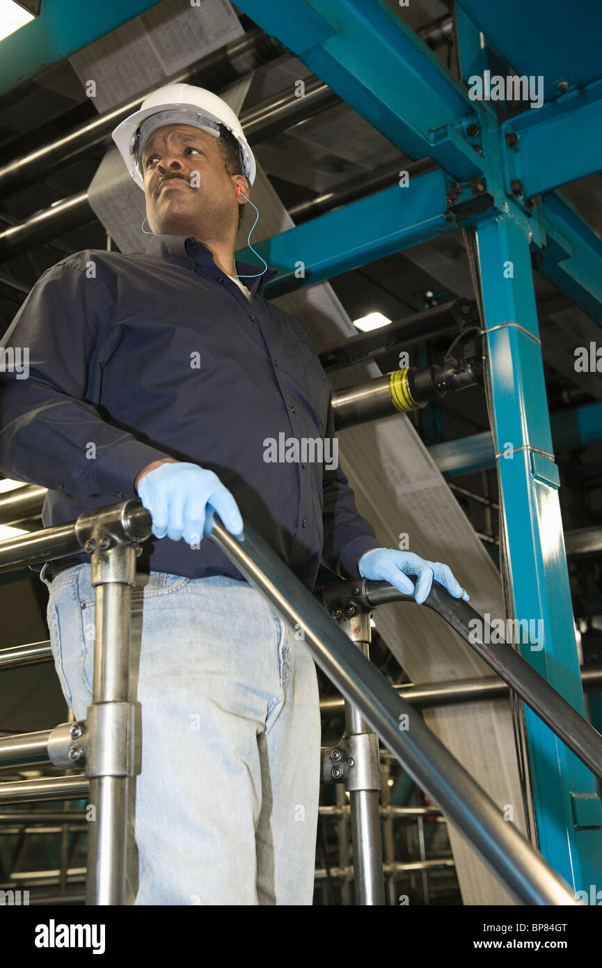 Mann arbeitet in Zeitung Fabrik, niedrigen Winkel Stockfoto