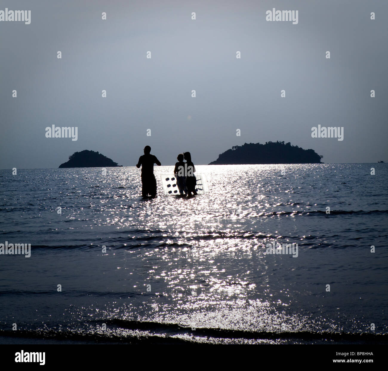 Familie Stand in das Meer und die Sonne mit einem Lilo, Koh Chang, Thailand. Stockfoto