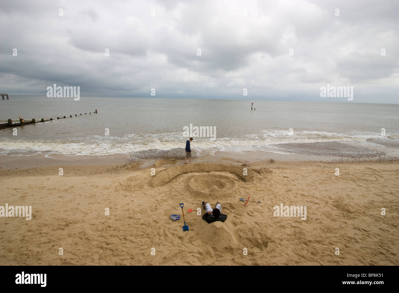 Southwold, Suffolk, Southwold Strand Wth Badegäste im Sand spielen Stockfoto