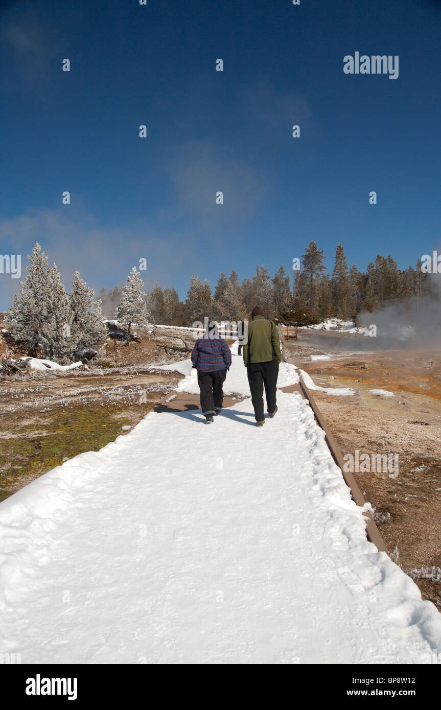 USA, Wyoming. Yellowstone-Nationalpark. Fountain Paint Pot Trail im Winter. Schneebedeckte Strecke neben heißen Schlammpfützen. Stockfoto