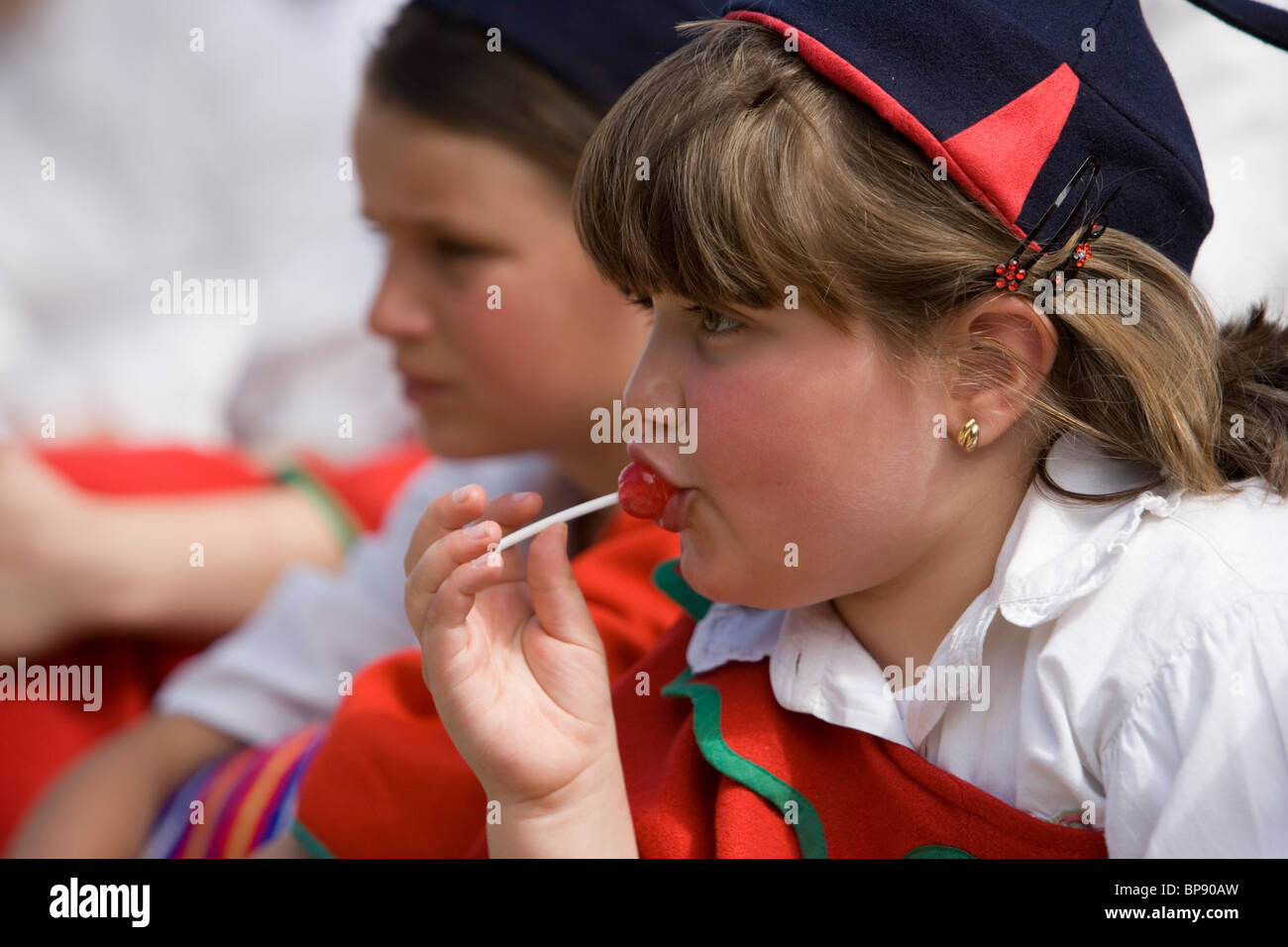 Mädchen genießen einen Lutscher während der Kinder-Parade auf dem Blumenfest von Madeira, Funchal, Madeira, Portugal Stockfoto Mädchen genießen einen Lutscher während der Kinder-Parade auf dem Blumenfest von Madeira, Funchal, Madeira, Portugal Stockfoto