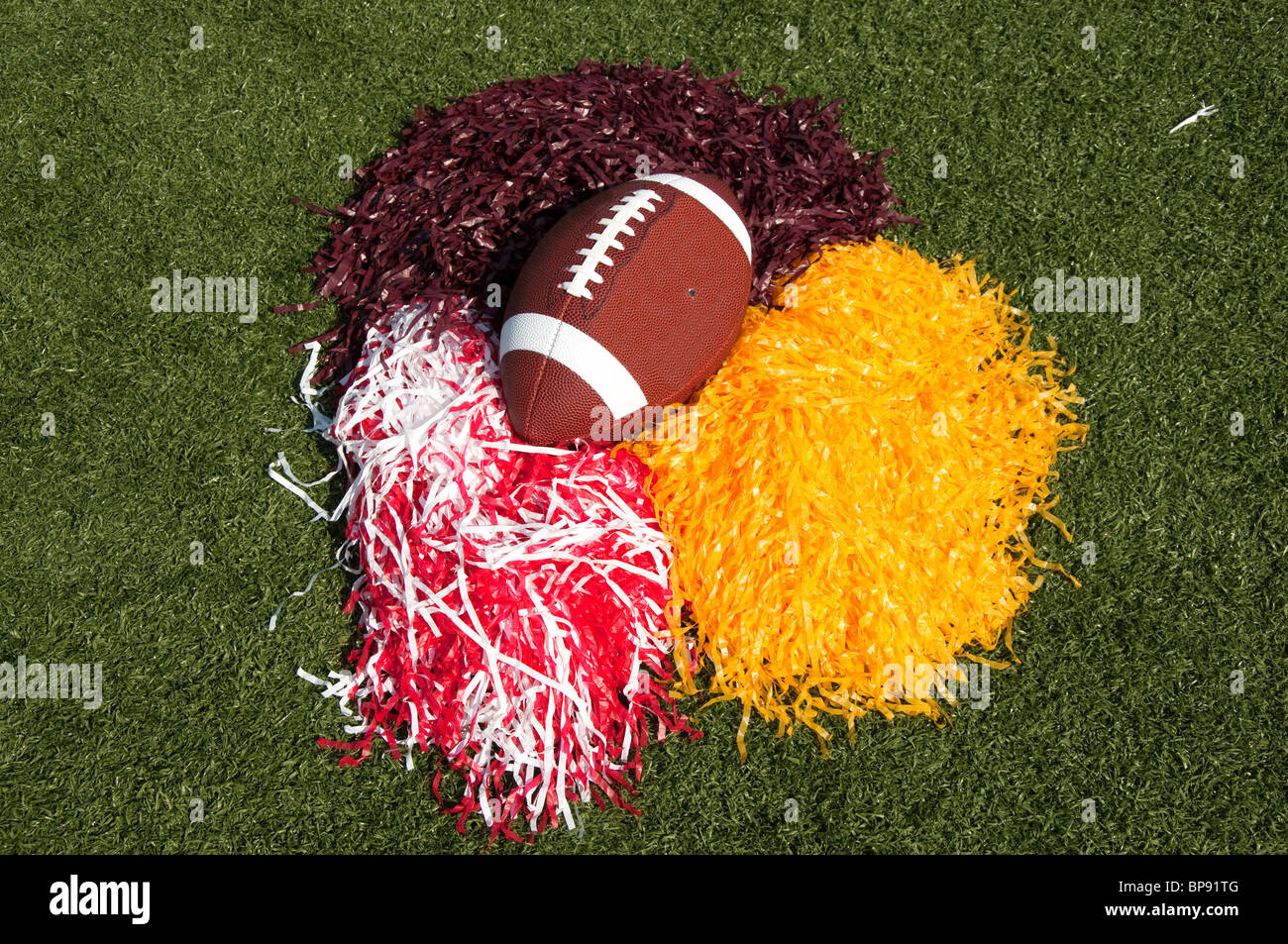 Amerikanischer Fußball und Pom-Poms auf Feld. Stockfoto