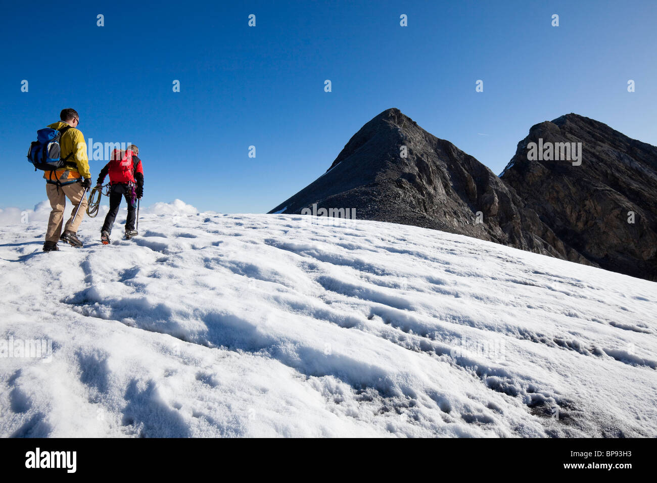 Zwei Männer wandern auf Huefifirn, Clariden im Hintergrund, Kanton Uri, Schweiz Stockfoto