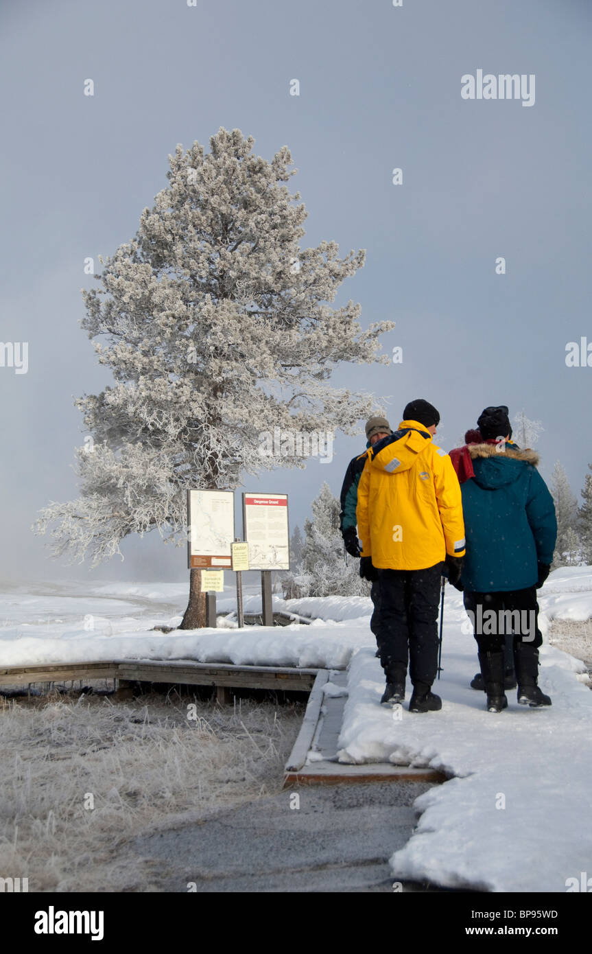 USA, Wyoming. Yellowstone-Nationalpark, Touristen zu Fuß entlang der Old Faithful im Winter. Stockfoto
