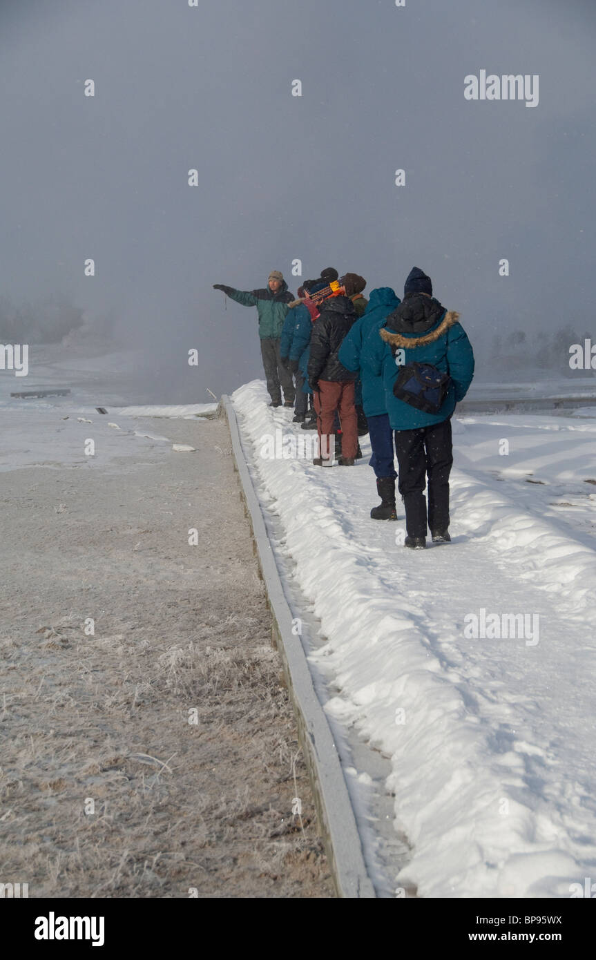 USA, Wyoming. Yellowstone-Nationalpark, Touristen auf den Old Faithful Geysir Trail im Winter. Stockfoto