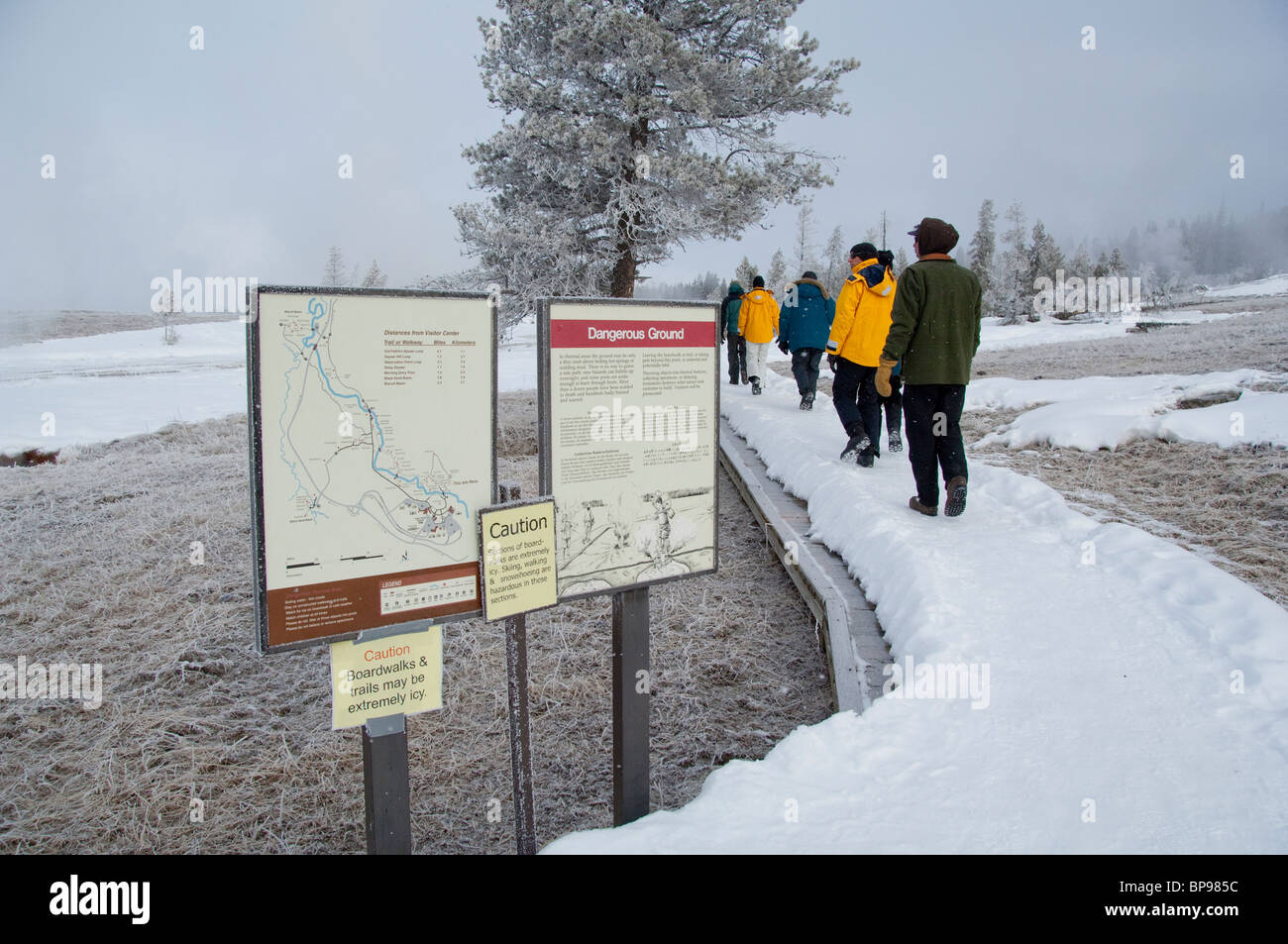 USA, Wyoming. Yellowstone-Nationalpark, Touristen zu Fuß entlang der Old Faithful im Winter. Stockfoto