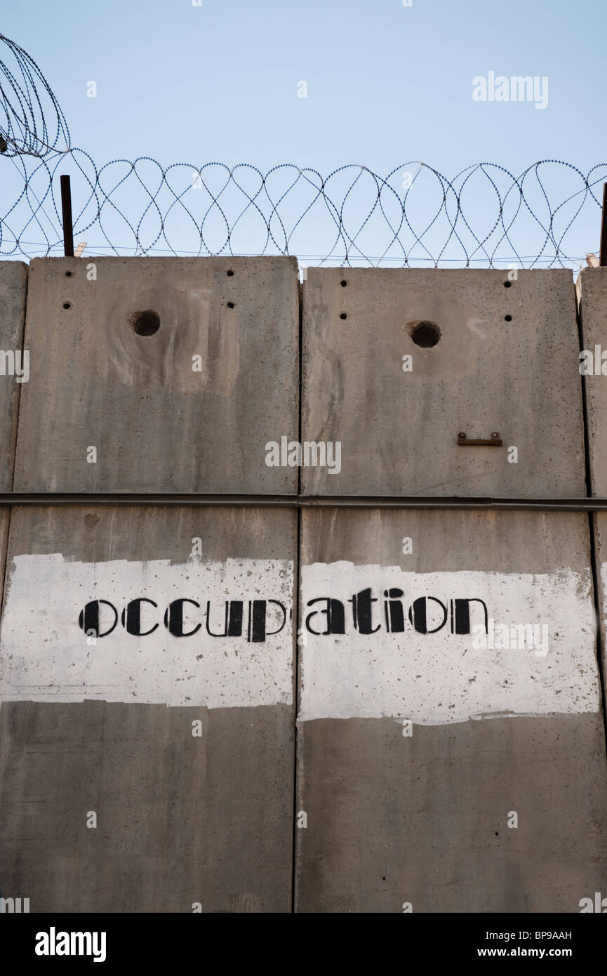 Lotnummer Graffiti 'Besetzung' zu lesen ist auf die israelischen Trennmauer isolieren einer palästinensischen Gegend gemalt. Stockfoto